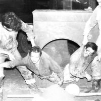 Комикс 2, Сцена 8 - Два бугая извлекают молоденьких строителей из трубы, ... а тут - и носилки гружёные бетоном подготовлены, и касочка лежит.